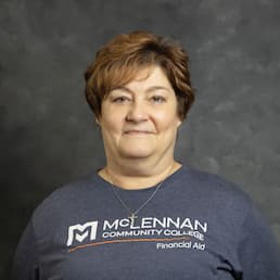 Portrait of a person wearing a McLennan Community College Financial Aid shirt against a gray backdrop.